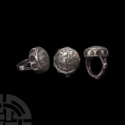 Timurid Silver Ring. 15th century A.D. A silver ring with rectangular-section hoop with engraved medial band, three raised roundels, openwork arms and...