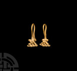 Bactrian Gold Earring Pair. 1st millennium B.C. A matched pair of gold earrings, each a wire hook with granule cluster finial. 1.60 grams total, 15-16...