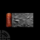 Mesopotamian Cylinder Seal with Offering Scene. 3rd-2nd millennium B.C. A carnelian cylinder seal drilled for suspension, bearing an incuse offering s...