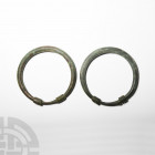 Large Western Asiatic Arm-Ring Pair. 2nd-1st millennium B.C. A large and heavy matched pair of arm rings composed of round-section bodies with overlap...