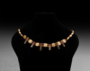 Bead Necklace with Silver Pendants. 1st millennium B.C. A restrung designer necklace of oval ceramic beads with oblate carnelian bead spacers, two str...