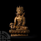 Sino-Tibetan Gilt Seated Buddha. 19th-20th century A.D. A gilt-bronze figure of Buddha sitting cross-legged on a lotus-flower dais wearing a crown and...