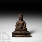 Sino-Tibetan Gilt Seated Buddha Figurine. 20th century A.D. A bronze figure of Buddha seated on a D-shaped gussetted dais, wearing a robe and flat-top...