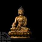 Sino-Tibetan Gilt Seated Buddha. 19th-20th century A.D. A gilt-bronze figure of Buddha sitting cross-legged on a lotus-flower dais wearing a mantle ut...