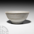 Chinese Tek Sing Shipwreck Porcelain Bowl. 19th century A.D. A pale blue-glazed bowl with bell-shaped profile, deep basal ring; official code label to...