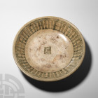 Chinese Large Tek Sing Shipwreck Dish. 19th century A.D. A broad white-glazed dish with blue arcaded pattern to the inner face, central calligraphic m...