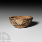 Indus Valley Offering Cup with Geometric Decoration. 3rd millennium B.C. A miniature carinated ceramic bowl with circumferential band of painted geome...