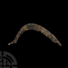 Viking Age Tanged Scythe. 9th-11th century A.D. An iron scythe composed of a curved blade with remains of teeth to the lower edge and a tapering recta...