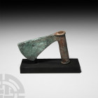 Luristan Sar'e Tabar Axehead. 3rd millennium B.C. A large bronze axe head with a curved cutting blade flaring down, tapering to a cylindrical shaft; a...
