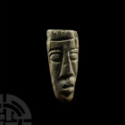 Mastodon Tusk Carving. Pliocene Period, 5.2-2.5 million years B.P. and later. A Mastodon sp. fossil tusk section, later carved with a stylised face to...