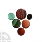 Round Polished Gemstone Group. A group of six coin-shaped gemstones, each displaying one or more polished faces; held in a white card collector's tray...