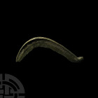 Bronze Age Tanged Sickle. 2nd millennium B.C. A bronze tanged sickle composed of a curved body with one blade and raised rim to one face. Cf. The Brit...