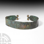 Bronze Age Belt with Coiled Terminals. c.1000 B.C. A woman's belt comprising of a wide penannular body with rounded ends, each with coiled finials; wi...