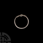 Viking Age Silver Pendant Ring. 9th-12th century A.D. A silver pendant ring composed of a round-section hoop, coiled wire bezel with central circular ...