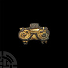 Anglo-Saxon Gilt Wrist Clasp. 6th-7th century A.D. A gilt chip-carved wrist clasp of anthropo-zoomorphic design, two pierced lugs (one incomplete) and...