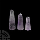 Cut and Polished Amethyst Crystal Obelisk Collection. A group of three graduated cut and polished amethyst obelisks; held in a white card collector's ...
