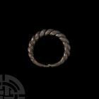 Viking Age Twisted Bracelet. 10th-11th century A.D. A substantial and solid penannular bronze bracelet formed from thick spiral twisted rods, flattene...