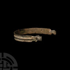 Viking Beast-Headed Bracelet. 9th-12th century A.D. A penannular bracelet composed of a flat-section body, raised and decoratively notched medial rib,...