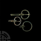 Viking Age Omega Cloak Brooches. 8th-11th century A.D. A set of three bronze omega cloak brooches of graduated size, two with free-running pins includ...