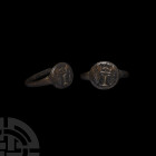 Medieval Ring with Crowned 'I'. 15th century A.D. A bronze finger ring with discoid bezel, incuse device of capital 'I' flanked by fronds with a styli...