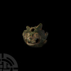 Medieval Lion's Head Mount. c.12th century A.D. A bronze lion head mount with conical body with flat apex, the notched bottom edge representing the an...