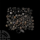 Glass Bead Collection. 20th century A.D. or earlier. A mixed group of over one hundred black glass beads including annular, spherical, facetted bicone...