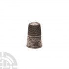 Silver Decorated Thimble. 18th century A.D. A silver thimble with dimpled upper body, the lower body decorated with stylised leaf motifs. 2.72 grams, ...