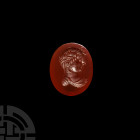 Post Classical Gemstone with Portrait. 19th-20th century A.D. A polished oval carnelian intaglio with youthful bust facing right, hair held by a fille...