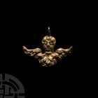 Gilt Silver Angel Pendant. 19th century A.D. A silver-gilt angel pendant with feathered wings and stylised facial detailing; suspension loop above. 7....