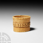 Bone Ferrule with Inscription. 19th century A.D. A roughly oval-shaped bone knife ferrule or napkin ring with raised medial band bearing enigmatic ins...