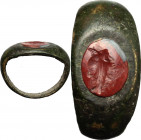 Bronze ring with carnelian intaglio engraved with 'grillos' (two joined faces). Roman period, 1st-2nd century AD. Gem 9 x 7 mm. Ring size 14,5 mm.