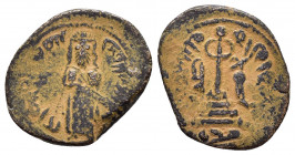 ARAB BYZANTINE.Early Caliphate.(636-660).Fals.

Obv : Caliph standing facing, placing hand on hilt of sword.

Rev : Long Φ on three steps; to left, wā...