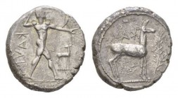 Bruttium, Caulonia Nomos Circa 475-425, AR 20.5mm., 7.81g. KAVΛ Naked Apollo standing r., holding branch in raised r. hand: on extended l. arm small r...