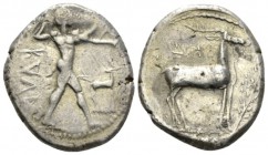 Bruttium, Caulonia Nomos circa 475-425, AR 20mm., 7.71g. Apollo advancing r., holding laurel branch and small running daimon; in field r., stag r. Rev...
