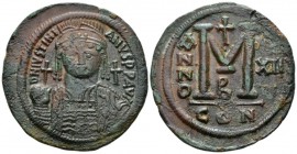 Justinian I, 527-565. Follis circa 538-539, Æ 42mm., 20.66g. Helmeted and cuirassed facing bust, holding globus cruciger and shield; cross to r. Rev. ...