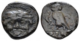 Sicily, Camarina Tetras circa 420-410, Æ 14mm., 3.17g. Gorgoneion, hair bound with fillet. Rev. Owl standing l. on one leg, clutching lizard with the ...
