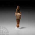 Egyptian Wooden Shabti with Original Shawl New Kingdom, 19th Dynasty, circa 1250 B.C. A carved wooden shabti modelled with head, wig and crossed arms,...