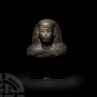 Egyptian Diorite Bust of a Dignitary Late Period, 525-330 B.C. A diorite bust of a male dignitary, modelled facing, wearing a wig, with stylised detai...
