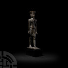 Egyptian Standing Figure of Amun-Re Late Period, 664-332 B.C. A bronze statuette of the god Amun-Re, modelled in the round in a striding pose on an in...