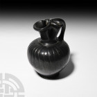 Greek South Italian Black-Glazed Trefoil Oinochoe Circa 4th-3rd century B.C. A black-glazed oinochoe with tapering body and broad rounded shoulder dec...