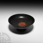 Greek Attic Black-Glazed Kylix Circa 5th century B.C. A black-glazed kylix or stemmed cup created without handles, composed of a D-section bowl with a...
