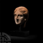 Life-Size Etruscan Terracotta Head 4th-2nd century B.C. A life-size terracotta head of a youthful woman, modelled with semi-naturalistic facial featur...