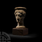 Greek Terracotta Head of a Female Wearing Polos 5th-3rd century B.C. A hollow-formed ceramic female head, modelled in the round wearing a polos, with ...