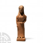 Greek Terracotta Peplos Kore Figure 6th-5th century B.C. A terracotta peplos kore figure modelled as a female standing on an integral base, wearing a ...