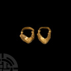Parthian Gold Earring Pair 3rd century B.C.-3rd century A.D. A matching pair of gold hoop earrings, each composed of a rectangular-section bar and fac...