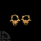 Parthian Gold Earring Pair 3rd century B.C.-3rd century A.D. A matched pair of gold earrings, each a crescent hoop with median bulb and rib, granulate...