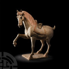 Chinese Tang Prancing Horse Tang Dynasty, 618-907 A.D. A ceramic horse modelled in the round prancing on a rectangular base, right foreleg raised, wit...