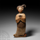 Chinese Tang Courtly Lady Tang Dynasty, 618-907 A.D. A terracotta figure of a lady in floor-length courtly dress decorated with a hand fan and floral ...
