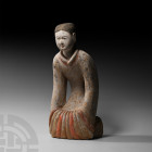 Chinese Han Kneeling Figure Han Dynasty, 206 B.C.-220 A.D. A ceramic figure of a female kneeling, wearing a floor-length robe and moon slippers, the h...