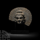 Gandharan Schist Head of Bodhisattva 2nd-4th century A.D. A schist bodhisattva head with nimbus decorated with concentric arcs of geometric motifs, te...